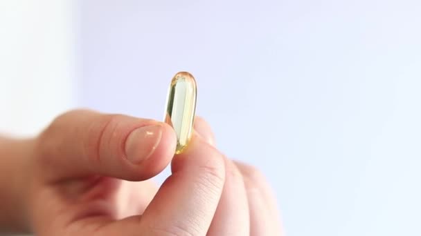 Medicijncapsule Vrouwelijke Handen Omega Heldere Gele Transparante Vitaminen Een Witte — Stockvideo