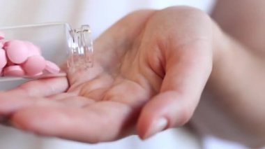 Haplar. Cam şişedeki pembe vitaminler. Vitaminleri avucunun içine dök. İlaç, sağlık ve uyuşturucu kullanımı kavramı. Salgın, ağrı kesici, sağlık sigortası, ilaç hapları.