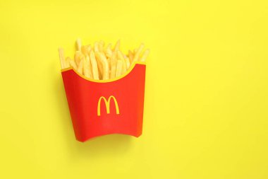 Kyiv, Ukrayna - 10 Ağustos 2023: Sarı arka planda patates kızartması. McDonald 's Corporation dünyanın en büyük fast food restoranıdır.