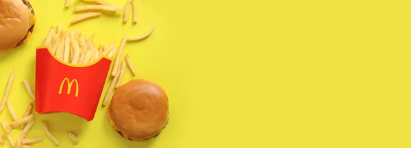 乌克兰基辅 2023年8月10日 在黄色背景下的纸包装和汉堡包中的薯条 顶部视图 麦当劳是世界上最大的快餐馆 复制空间 — 图库照片