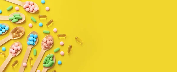 Vitaminas Cores Diferentes Colheres Madeira Fundo Amarelo Visão Superior Pílulas — Fotografia de Stock