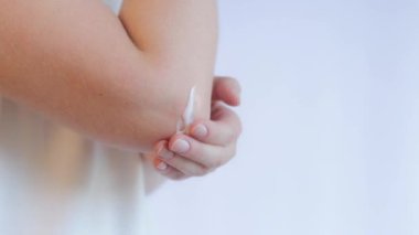 Dirseğe krem sür. Güzellik ve vücut bakımı. Dirsek ağrısı ve sağlık konsepti. Cilde losyon ya da nemlendirici sür, açık arkaplan