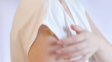 Bir kızın omzunda yara bandı var. Bir doz kovid virüs aşısı, sağlık aşısı, kuduz aşısı aldıktan sonra. Aşılanmış bir kız, sıhhiye alçısıyla elini gösteriyor.