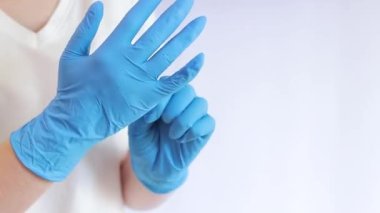 Lateks eldivenli eller. Doktor, hafif arka plan üzerine lastik mavi eldivenler takıyor, yakın plan. Tıp ve sağlık hizmetleri kavramı. Doktor ya da hemşire azot koruyucu eldiven giyiyor.