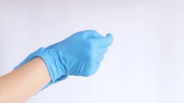 Lateks eldivenli eller. Doktor, arka planda hafif çekimde ellerindeki lastik mavi eldivenleri çıkarır, yakın plan. Tıp ve sağlık hizmetleri kavramı. Doktor ya da hemşire nitril eldiven giyiyor.