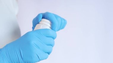 Lateks eldivenli eller bir kavanoz hap tutuyor. Tıp ve sağlık hizmetleri kavramı, farmakoloji. Doktor vitamin gösteriyor.