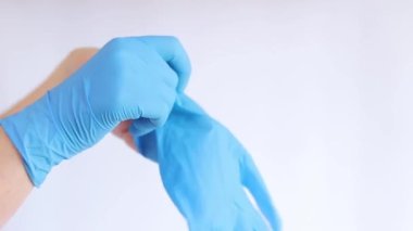 Lateks eldivenli eller. Doktor, hafif arka plan üzerine lastik mavi eldivenler takıyor, yakın plan. Tıp ve sağlık hizmetleri kavramı. Doktor ya da hemşire azot koruyucu eldiven giyiyor.