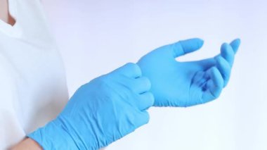 Lateks eldivenli eller. Doktor, hafif arka plan üzerine lastik mavi eldivenler takıyor, yakın plan. Tıp ve sağlık hizmetleri kavramı. Doktor ya da hemşire azot koruyucu eldiven giyiyor.