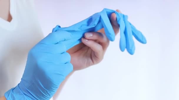 ラテックスメディカルグローブの手 医者はゴム製の青い手袋を軽い背景に 閉じ込めました 医療と医療のコンセプト ニトリル保護グローブを着用している医師または看護師 — ストック動画