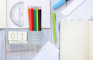 01 Eylül. Masanın üstünde 1 Eylül için ahşap bir takvim resmi var. Sonbahar günü. Okula dönelim. Kırtasiye, not defteri ve daimi takvim