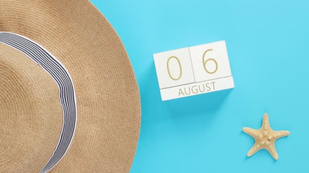 蓝色背景的木制日历 配有夏季附件 顶部视图 夏天的假期 永恒的日历 帽子和海星 日期由1日改为31日 — 图库视频影像