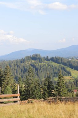 Karpat dağlarının ve yerleşim yerlerinin manzaraları. Seyahat konsepti. Tepeler, dağlar, gökyüzü ve bulutlar