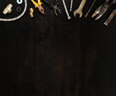 Ahşap bir masanın üst görüntüsü ve bir tarafında çalışan bir alet var. Paslı eski bir alet arka arkaya dizilmiş. Metin için araçlar ve boş alan. Babalar Günü için kompozisyon