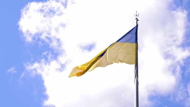 青い空と白い雲の背景にあるウクライナの国旗 ブルーとイエローの旗 ウクライナの国旗 — ストック動画