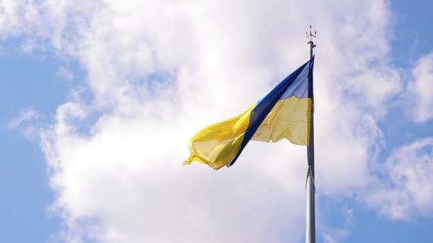 青い空と白い雲の背景にあるウクライナの国旗 ブルーとイエローの旗 ウクライナの国旗 — ストック動画