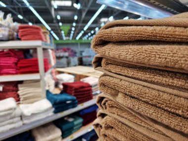 Kahverengi havlular yakın çekimde bir yığın halinde duruyor. Ev yapımı güzel havlular bir mağazanın rafında katlanmış.