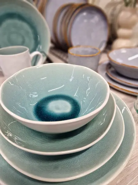 Ceramic tableware, plates and cups, selective focus. Dishes in the store. A variety of ceramic tableware, plates, bowls and glazed dishes. A set of ceramic, stylish dishes