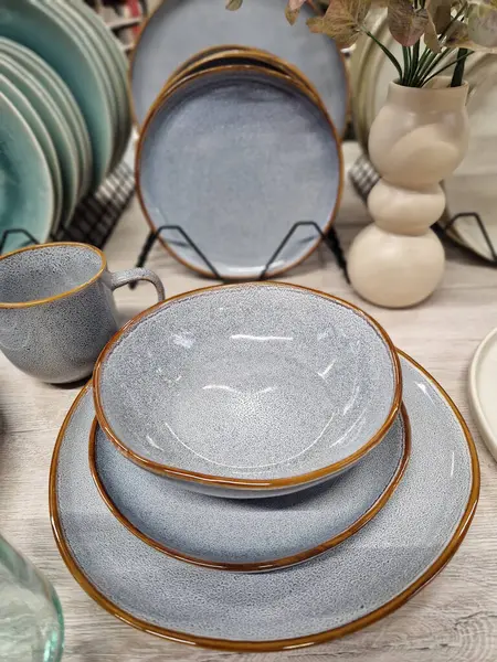Ceramic tableware, plates and cups, selective focus. Dishes in the store. A variety of ceramic tableware, plates, bowls and glazed dishes. A set of ceramic, stylish dishes