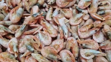 Süpermarkette donmuş karides satmak. Balık pazarında karides, düzgün kamera hareketi. Deniz ürünleri. Süpermarketin buzdolabında çiğ karides.