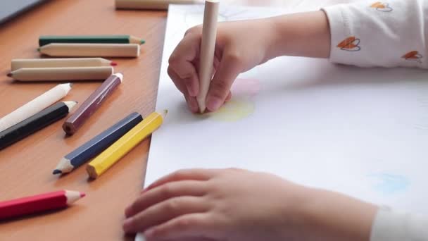 一个孩子用彩色铅笔在相册上画画 儿童的创造力 在幼儿园 学校或家中学习 孩子的手与铅笔近距离 有选择的焦点 女孩画了一幅画 — 图库视频影像