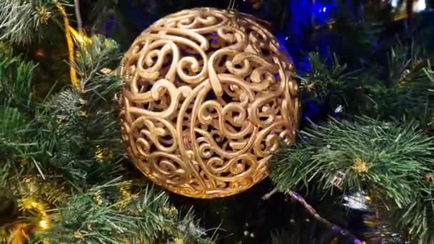 金のクリスマスツリーのおもちゃ クリスマスボール クリスマスツリーの装飾 ガーランドの青い光の一部を閉じます クリスマスツリー — ストック動画