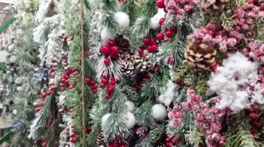 Yılbaşı dekoru, beyaz topları olan yapay dallar - böğürtlen, kozalak, Noel ağacı dalları. Noel ağacı süslemelerine yakın çekim. Süpermarkette Yeni Yıl Dekoru Satışı