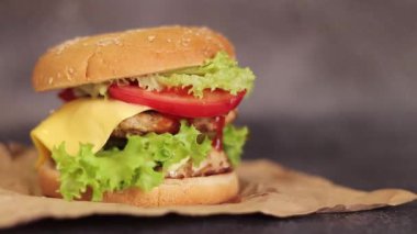 Gri arka planda duble çizburger. Lezzetli hamburgerler kağıt üzerinde, yan görüş. Fast food. Boşluğu kopyala