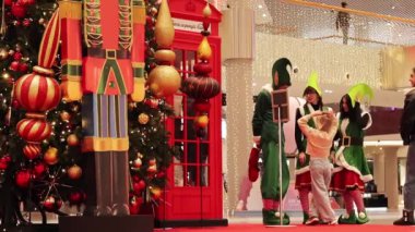 Kyiv, Ukrayna - 5 Aralık 2023: Yeni yıl ağacının yakınındaki bir alışveriş merkezinde Noel elfleri. Festivalci kostümlü insanlar ziyaretçilerine mutlu Noeller diliyor. Bir alışveriş merkezinde Noel ağacı