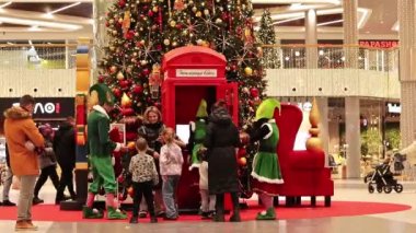Kyiv, Ukrayna - 5 Aralık 2023: Yeni yıl ağacının yakınındaki bir alışveriş merkezinde Noel elfleri. Festivalci kostümlü insanlar ziyaretçilerine mutlu Noeller diliyor. Bir alışveriş merkezinde Noel ağacı