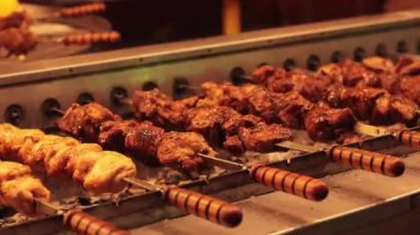 Şiş kebap, otomatik ızgara, yakın çekim. Noel yemekhanesi, adil, kış. İyi akşamlar. Sıcak, lezzetli yemekler. Seçici odaklanma. Otomatik ızgara şişleri döndürür