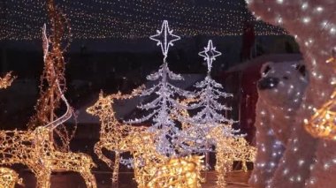 Kyiv, Ukrayna - 12.24.2023: Noel şehir dekorasyonu. Yeni yıl dekoru alışveriş merkezinin yakınında. Akşamları ya da akşamları bir çelengin içinden parlayan geyik figürleri, neşeli bir atmosfer.
