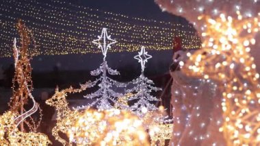 Kyiv, Ukrayna - 12.24.2023: Noel şehir dekorasyonu. Yeni yıl dekoru alışveriş merkezinin yakınında. Akşamları ya da akşamları bir çelengin içinden parlayan geyik figürleri, neşeli bir atmosfer.