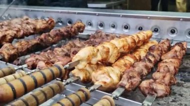Kebap şiş, otomatik ızgara yakın çekim. Panayırda yemek, kışın dışarıda yemek. Sıcak ve lezzetli yemekler. Şiş kebap, kömürlü et.