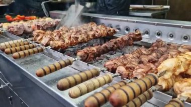 Kebap şiş, otomatik ızgara yakın çekim. Panayırda yemek, kışın dışarıda yemek. Sıcak ve lezzetli yemekler. Şiş kebap, kömürlü et.