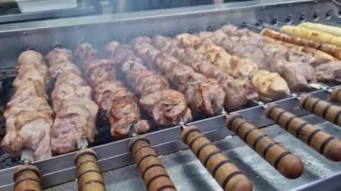 Kebap şiş, otomatik ızgara yakın çekim. Panayırda yemek, kışın dışarıda yemek. Sıcak ve lezzetli yemekler. Şiş kebap, kömürlü et.
