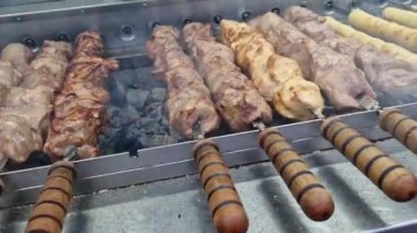 Kebap şiş, otomatik ızgara yakın çekim. Panayırda yemek, kışın dışarıda yemek. Sıcak ve lezzetli yemekler. Şiş kebap, kömürlü et.