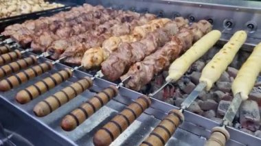 Kebap şiş, otomatik ızgara yakın çekim. Panayırda yemek, kışın dışarıda yemek. Sıcak ve lezzetli yemekler. Şiş kebap, kömürlü et.