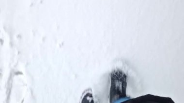 Kadınların ayakları kışın karda yürür, birinci şahıs görüşü. Karda yürüyen insan ayaklarının yakın çekimi. Kışın yürü