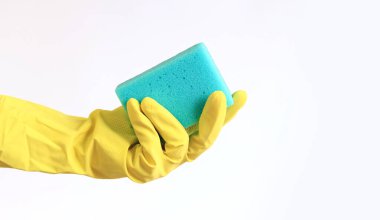 Sarı lateks eldivenli bir kadının eli bulaşık süngeri tutuyor. Binayı temizliyorum. Profesyonel temizlik. Ev eldivenleri, sarı. Temizlikçi kadın