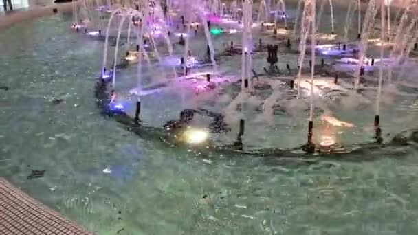 Brunnen Mit Farbiger Beleuchtung Einem Einkaufszentrum Abends Die Wasserstrahlen Schließen — Stockvideo