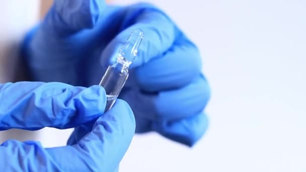 Keze Egy Kék Orvosi Kesztyűben Egy Gyógyszeres Üvegampullát Tart Üvegampullák — Stock videók