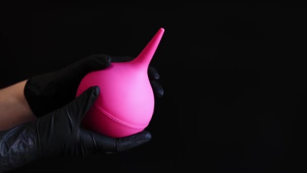 Hand Black Latex Glove Holds Large Pink Enema Dark Background — Stock Video