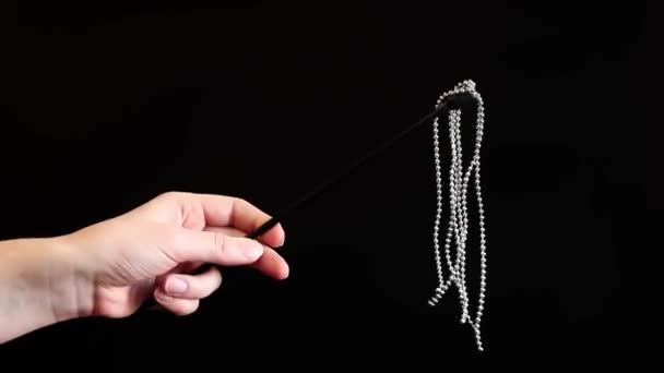 ハンドは暗い背景に金属のボールが付いている装飾的な鞭を握ります 女性の手にセックスアクセサリー セックス玩具 セックスショップのコンセプト — ストック動画