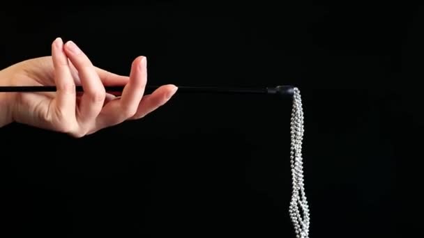 ハンドは暗い背景に金属のボールが付いている装飾的な鞭を握ります 女性の手にセックスアクセサリー セックス玩具 セックスショップのコンセプト — ストック動画