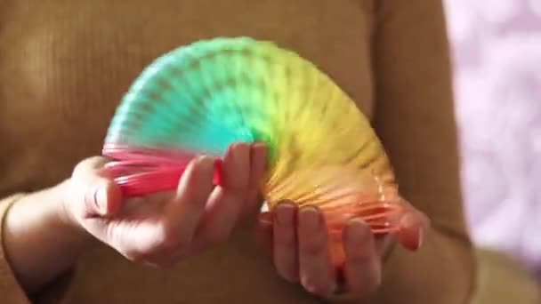 彩虹春玩具 一个柔软的塑料玩具彩虹色在一个女人的手中 展示一个有趣的塑料玩具 — 图库视频影像