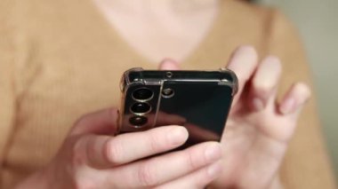 Cep telefonu tutan bir kadının yakın çekimi var. Akıllı telefon teknolojisi, bir kadının elinde cep telefonu. İnternet aramaları, sosyal ağlar, online alışveriş ve daha fazlası. Modern aygıtlar