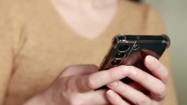Cep telefonu tutan bir kadının yakın çekimi var. Akıllı telefon teknolojisi, bir kadının elinde cep telefonu. İnternet aramaları, sosyal ağlar, online alışveriş ve daha fazlası. Modern aygıtlar