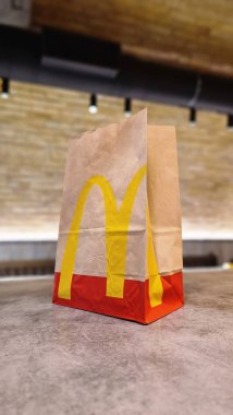 Kyiv, Ukrayna - 28 Şubat 2024: Masada McDonald 's fast food restoranı logosu olan bir kese kağıdı. McDonald 's için paket poşeti ve paket yiyecek.