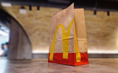Kyiv, Ukrayna - 28 Şubat 2024: Masada McDonald 's fast food restoranı logosu olan bir kese kağıdı. McDonald 's için paket poşeti ve paket yiyecek.