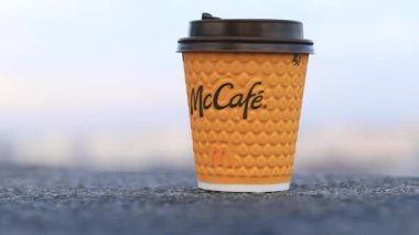 Kyiv, Ukrayna - 28 Şubat 2024: McCafe içecekleri için kağıt bardak. Fast food restoranından bir şeyler içmek. McDonalds 'ın kahveli tek kullanımlık sarı fincanı.